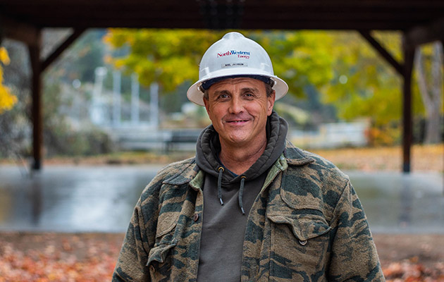 Employee Noel Jacobson wears a hard hat and smiles in Power Park.